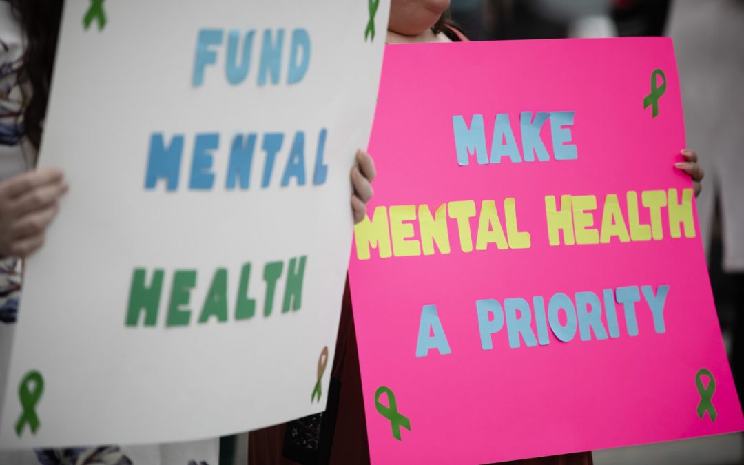 Demonstrators holding signs about making healthcare a priority