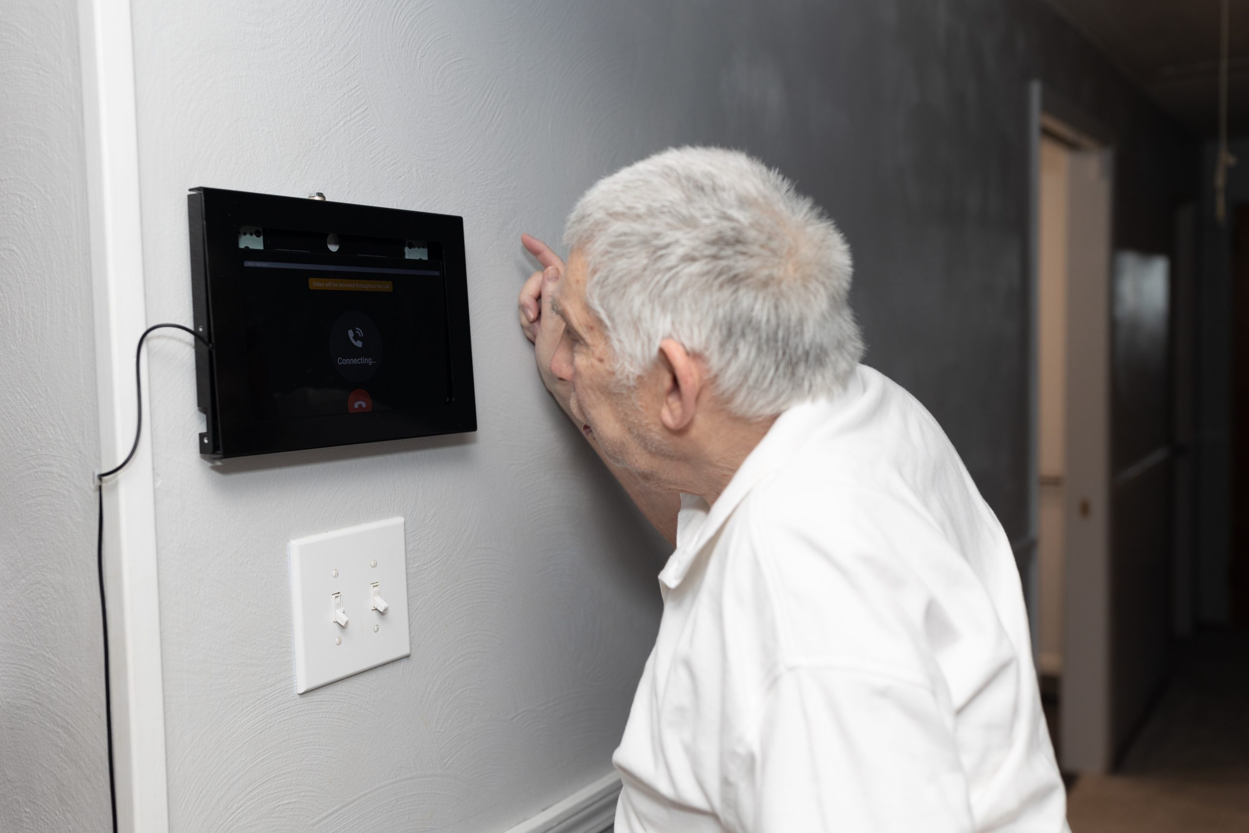 Older man using a touch pad for technology services