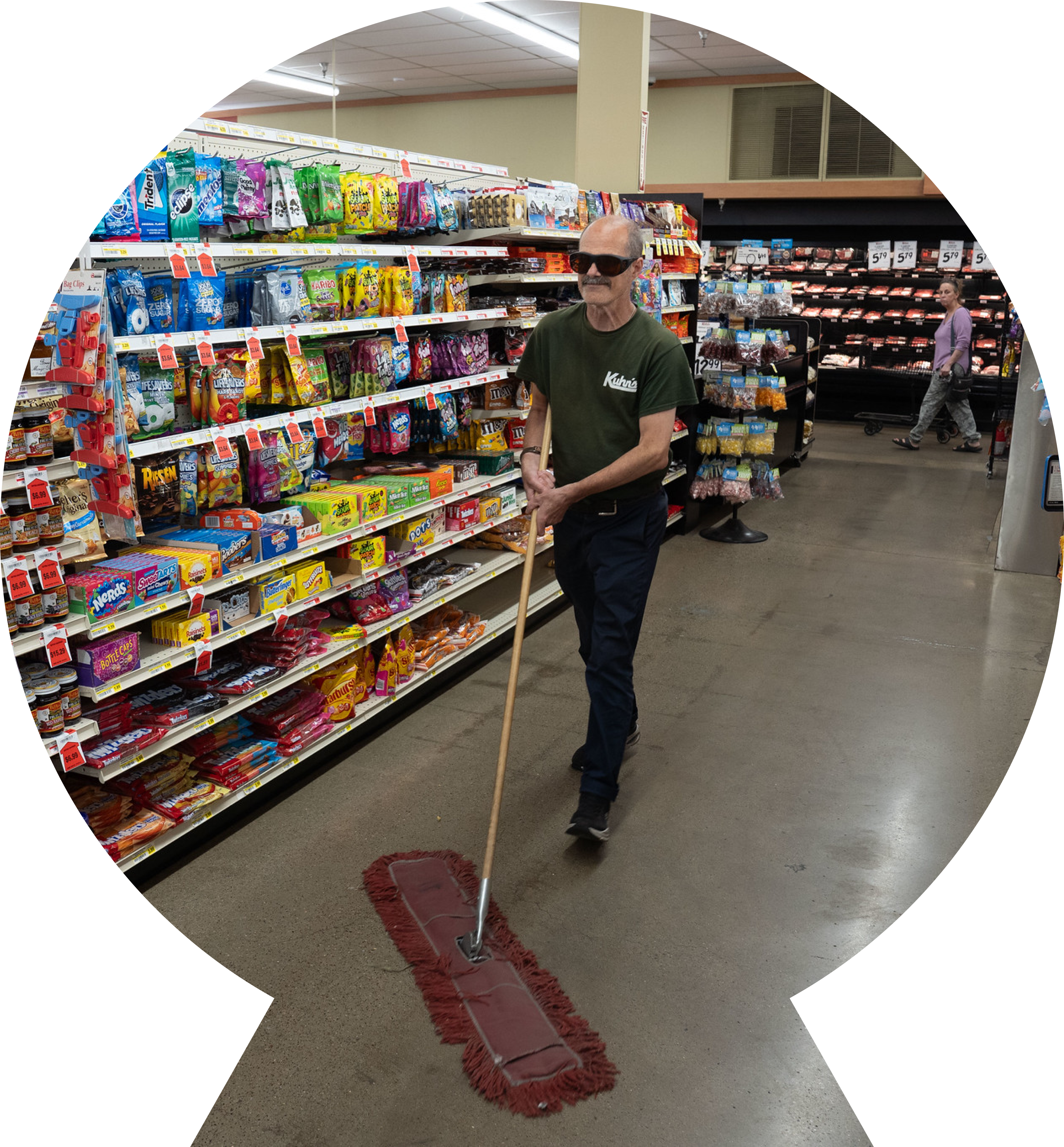 Man mopping the aisle floors of a grocery store, while working.