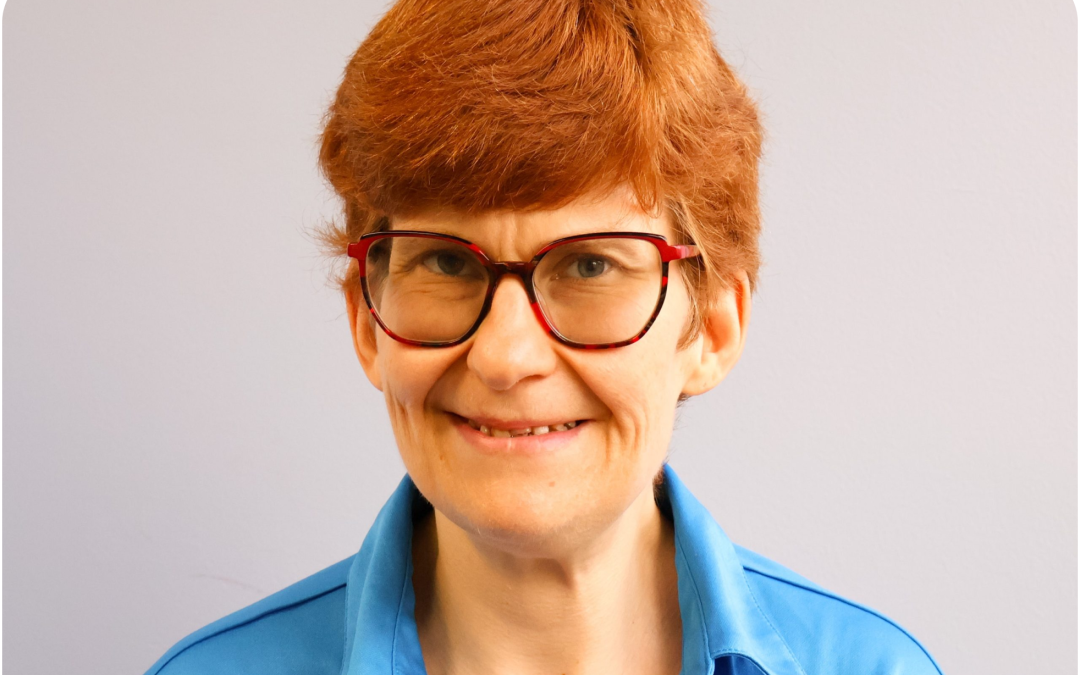 Lindsay smiling for a headshot in her glasses