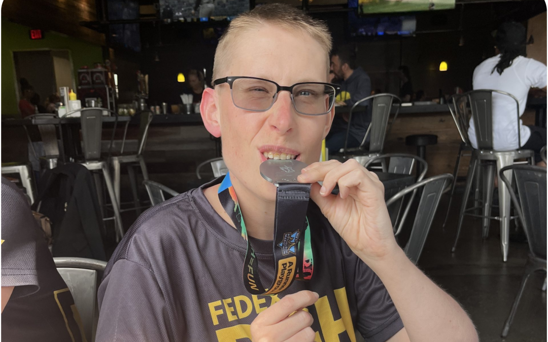 Stephen biting his medal in celebration of a race