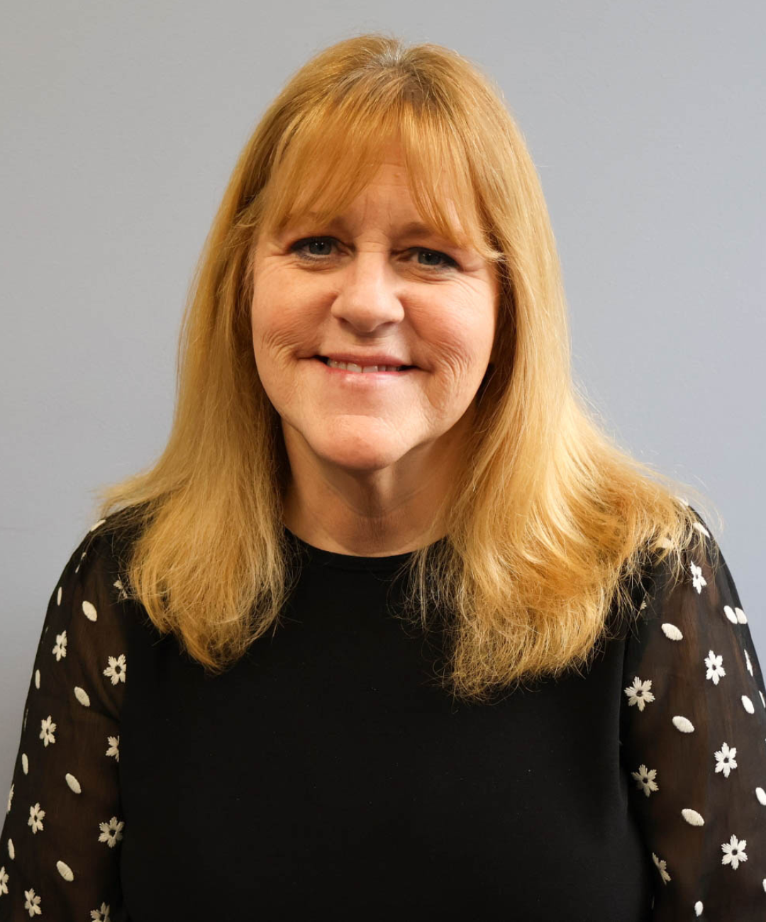 Woman stocking shelves while smiling for the camera